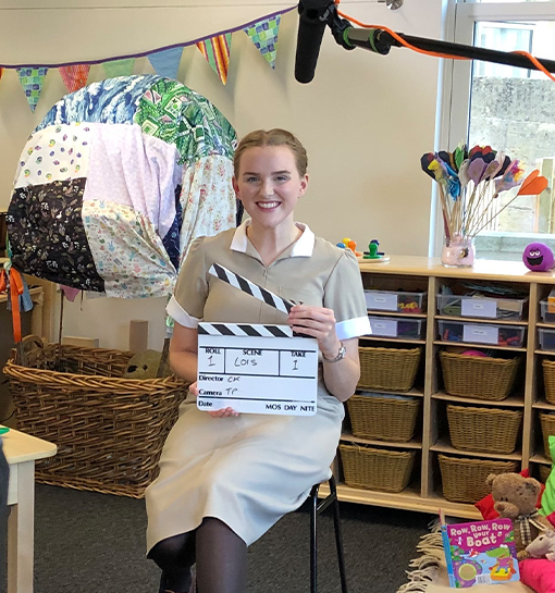 a female in uniform on a film set with a clapper board