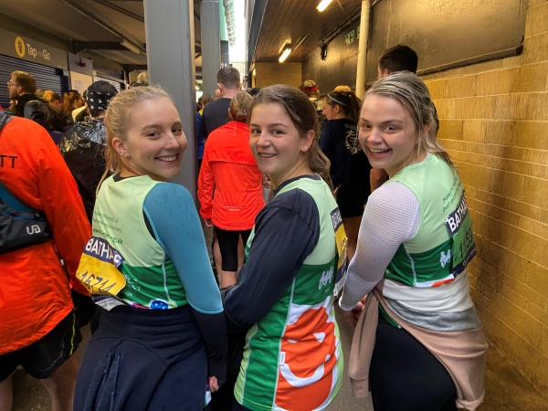 three women standing in fancy dress after a maratho