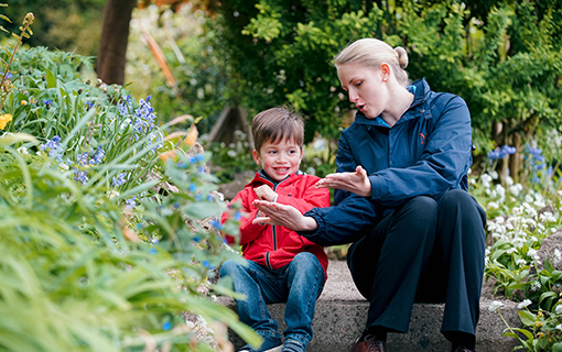 boy and female Norland nanny in a garden