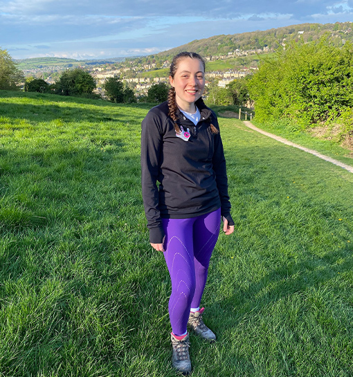 a female in hiking attire in a field