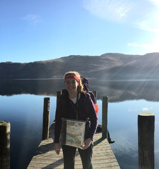 a female stood on a pier in front of some water