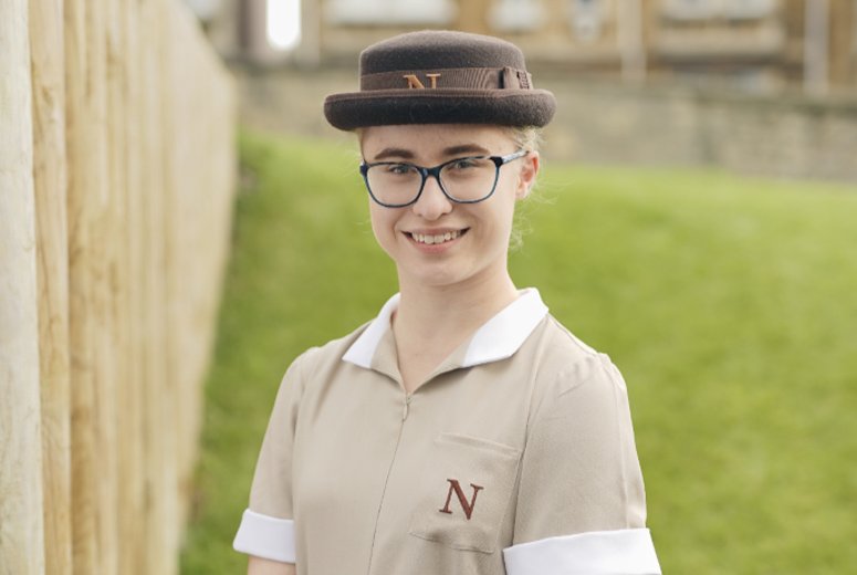 a student in uniform stood on grass