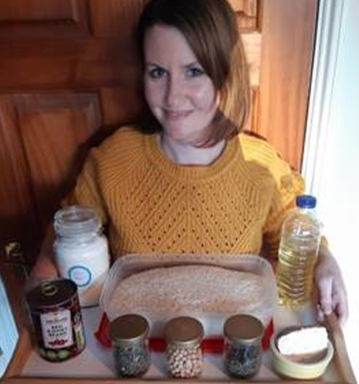 a female member of staff holding a tray of food rations