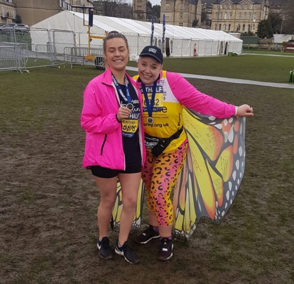 two women standing in fancy dress after a marathon