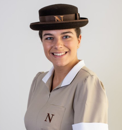 a female student in her formal uniform smiling