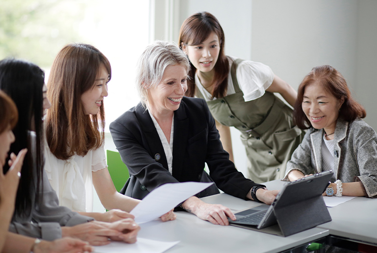 group of students looking at lecturer's laptop