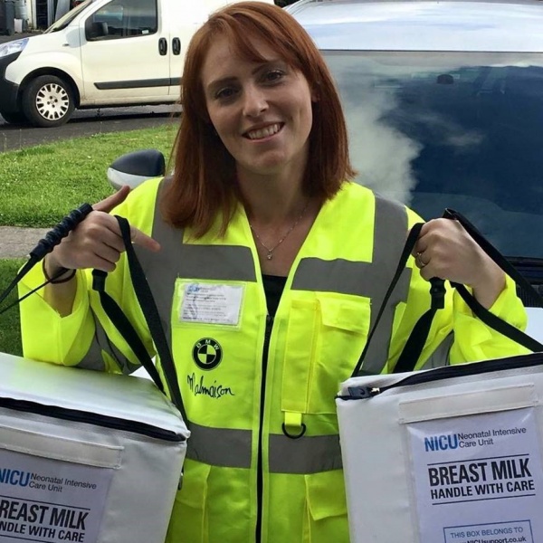 lady in high vis jacket holding packs of breast milk