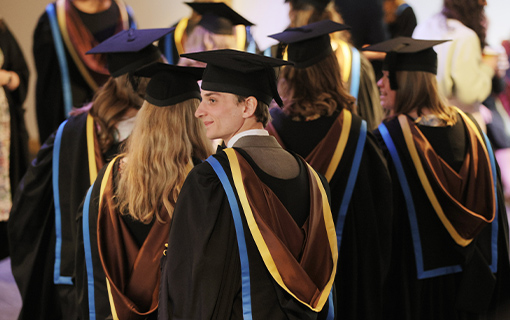 a male Norland student at graduation wearing his gowns