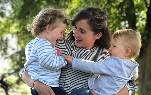 A woman holding two babies