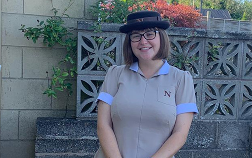 a female student in her formal uniform smiling